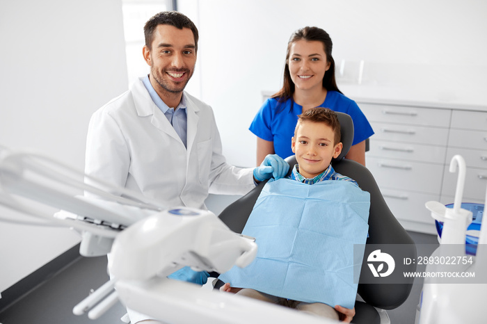 medicine, dentistry and healthcare concept - happy dentist, assistant and kid patient at dental clin