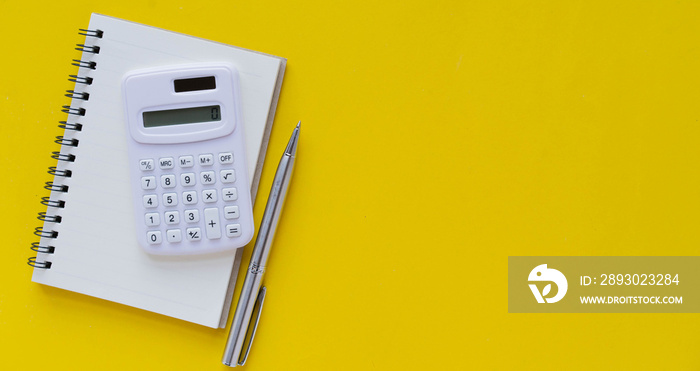 close up white calculator with notebook and pen for note about cost of living or financial business 