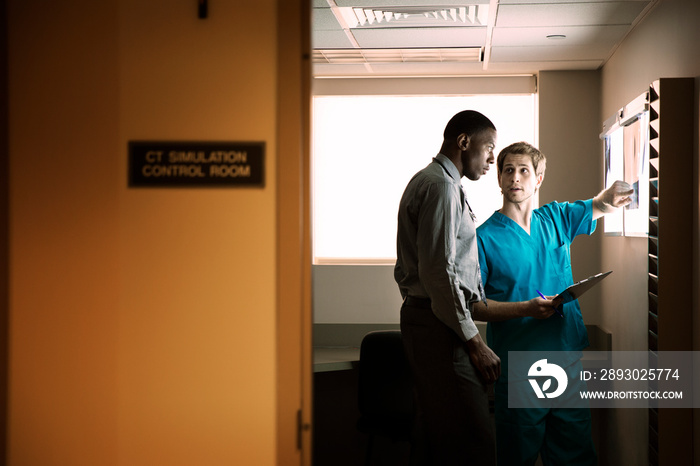 Male doctor showing x-ray images to patient