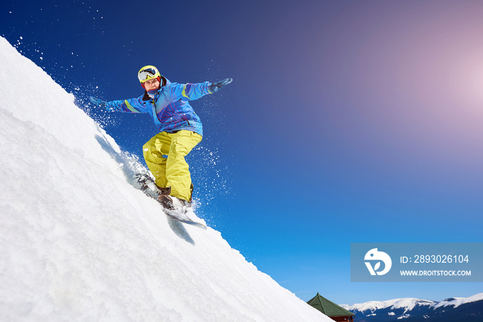 一个家伙在山坡上滑雪。一个年轻人在冬天滑雪对抗蓝色的肖像