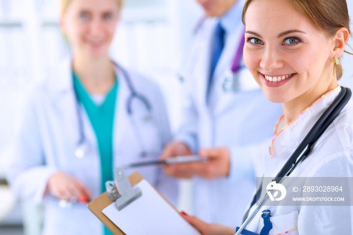 Attractive female doctor  with folder in front of medical group