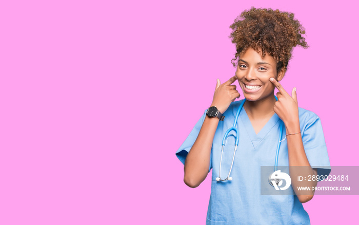 Young african american doctor woman over isolated background Smiling with open mouth, fingers pointi