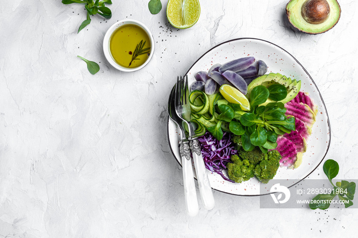 vegan salad with sweet potatoes, broccoli, avocado, purple cabbage, cucumber, watermelon radish and 