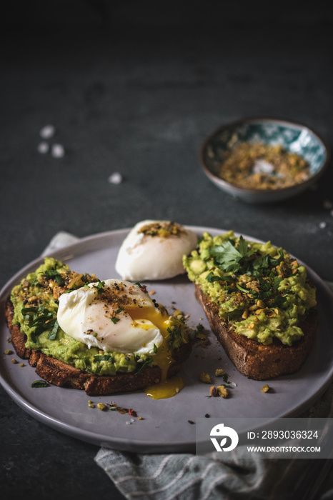 Poached egg on top of the sourdough toast with smashed avocado and dukkah spice