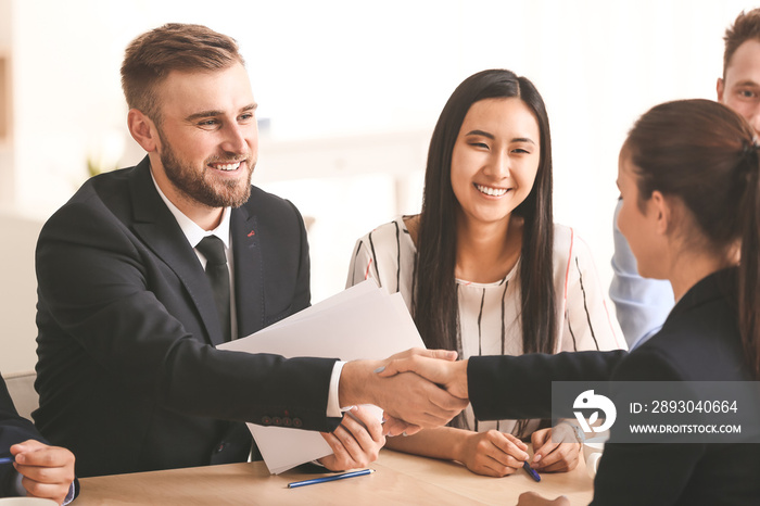 Human resources manager shaking hands with applicant after successful interview