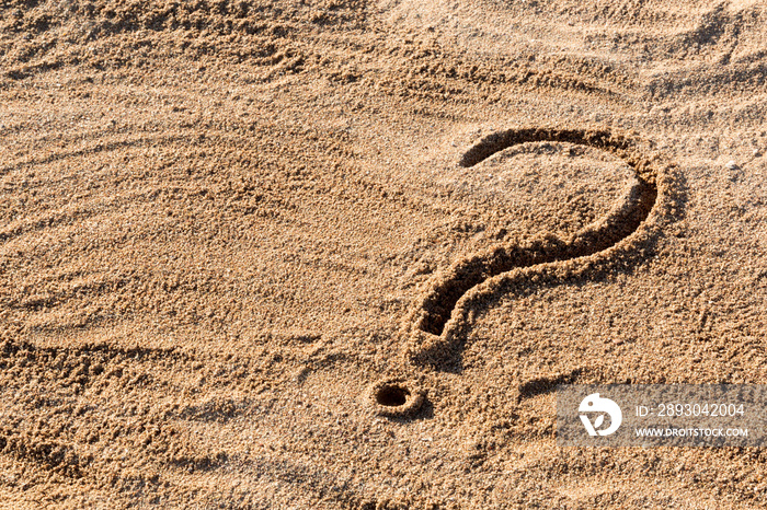 question marks written on beach sand close up, with copy space