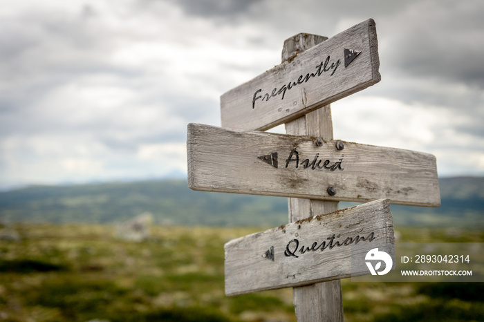 frequently asked questions text on wooden signpost outdoors in nature.