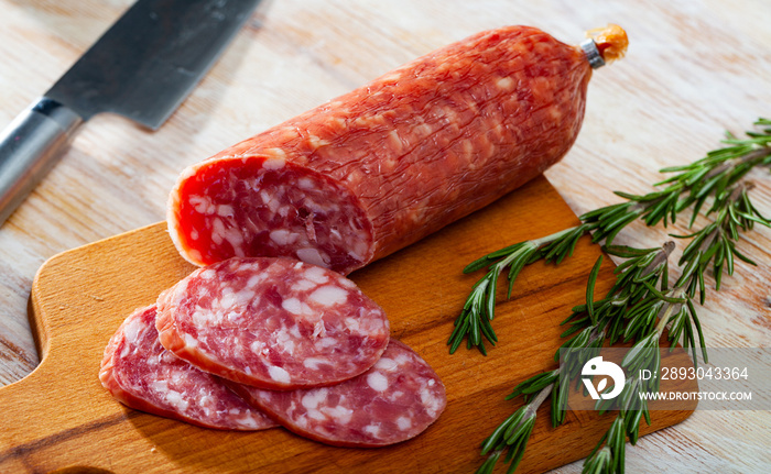 View of traditional spanish smoked salchichon sausage on wooden cutting board