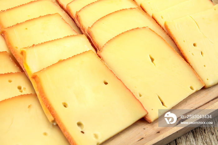 tranches de fromage à raclette sur une planche à découper