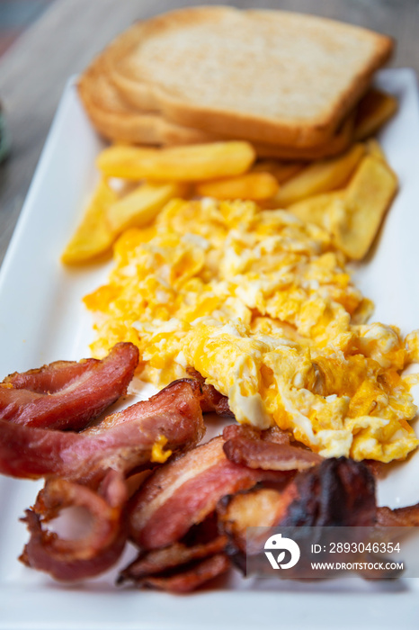 Grilled toasts served with beans, scrumbled eggs and sausage for an English breakfast.