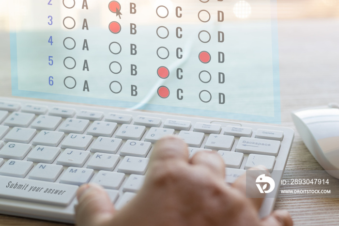 Dry hand of adult student using white keyboard on table to do test examination with multiple choice 