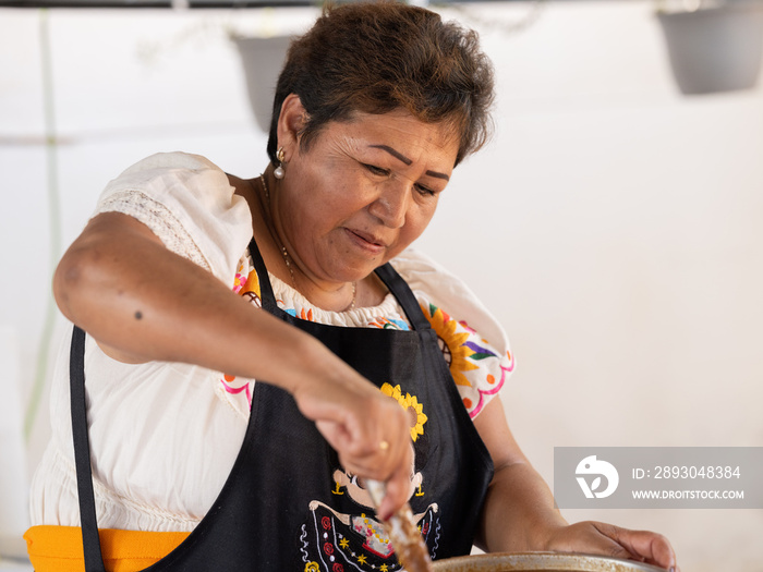 Close portrait of an Indigenous woman concentrated on cooking