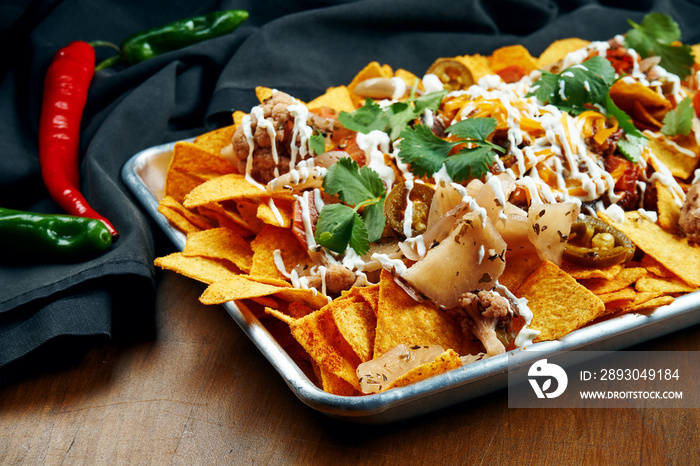 Nachos - A classic Mexican appetizer made from corn tortilla chips. Nachos with sauces and holopenya