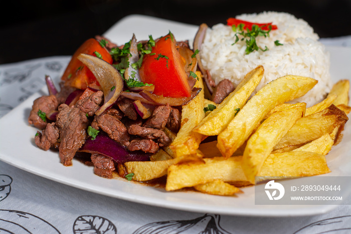 Peruvian traditional food. A beef with tomatoes, onion, rice and fried potatoes, Lomo saltado