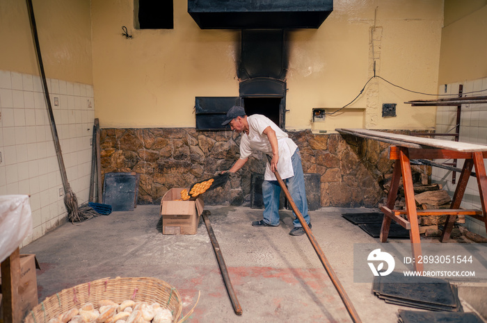 Panaderia antigua con horno de leña. Hombre Latino haciendo pan.