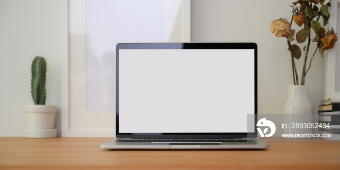 Cropped shot of modern workplace with laptop computer, office supplies and decorations