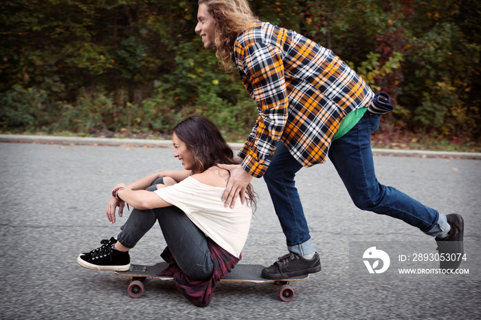 Young couple skateboarding in park