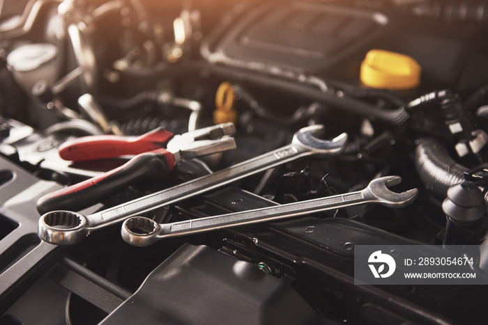 Mechanic hand checking and fixing a broken car in car service garage