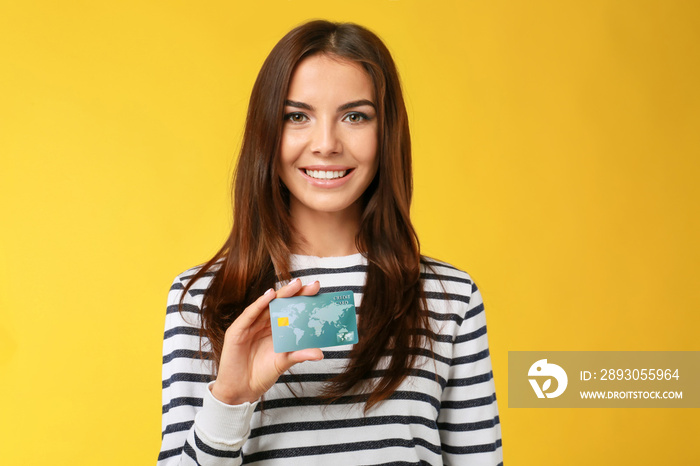 年轻女子，带着彩色背景的信用卡和钱包。网上购物