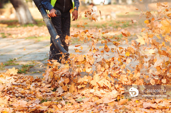 秋天，穿着制服的工人正在清理城市街道上的落叶