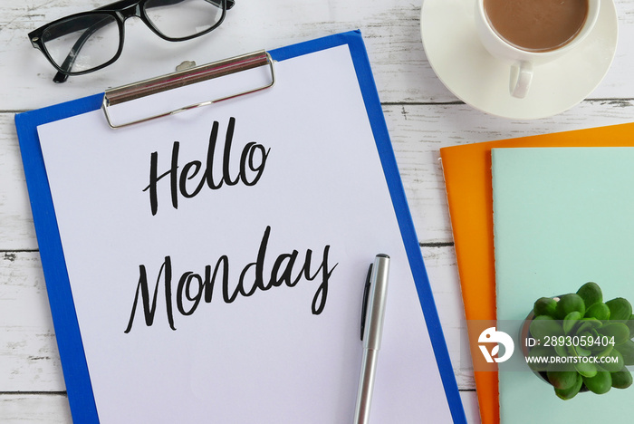 Top view of glasses,coffee,plant,notebook,pen,clipboard and paper written with Hello Monday.