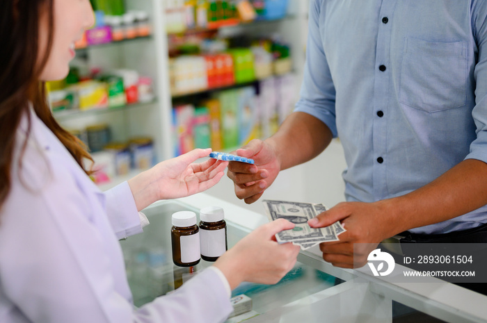 hands of selling pharmacist and man customers buyin medicine in drug store