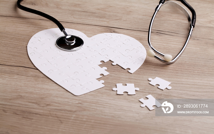 Stethoscope on puzzle, solving the mystery of health care