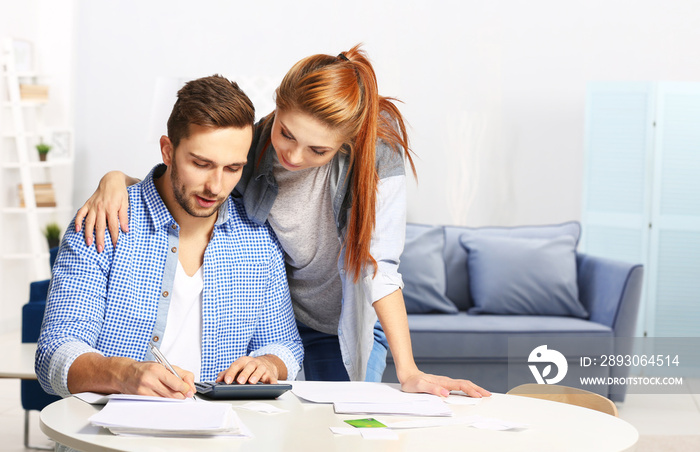 Young couple calculating taxes at home