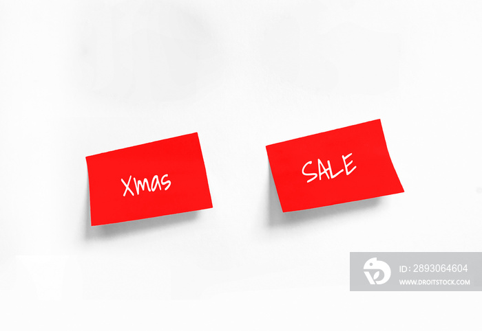 Xmas and Sale Handwriting text on two Red stickers on white Whatman paper. Concept of sale, christma