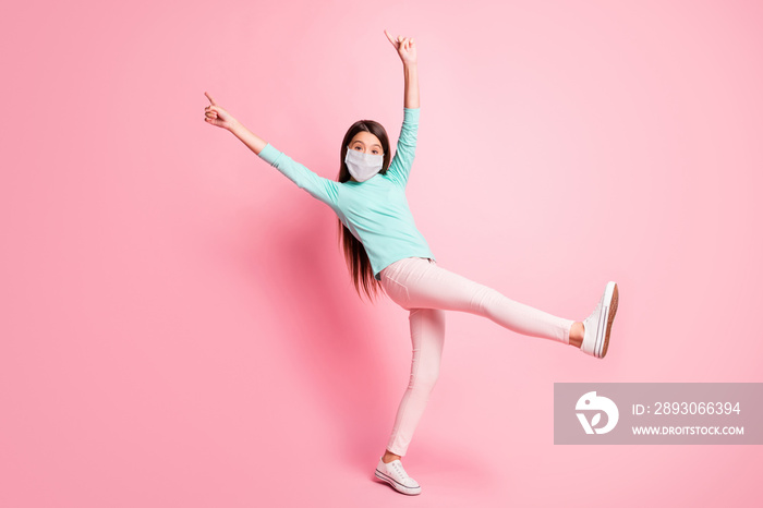 Full length photo of little lady dance raise hands fingers wear mask teal sweatshirt pants white sne