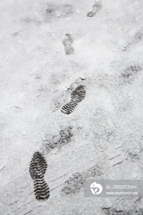 Shoeprints,footprints,bootprintd on ground coved by white snow.be careful to walking on the snow.