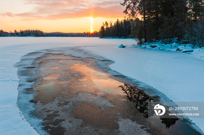 Sunrise at frozen winter lake