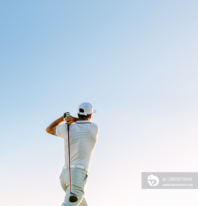 男子在晴朗的天空中挥动高尔夫球杆