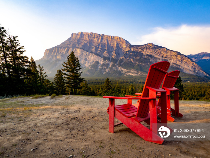 chaises rouges devant une montagne au lever de soleil