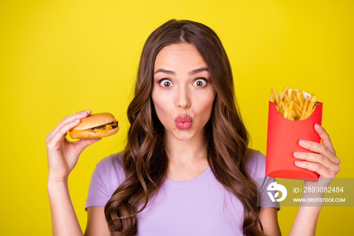 Close-up portrait of pretty cheerful funky hungry wavy-haired girl eating french fries burger pout p