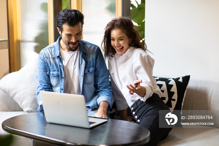 Happy young family couple shopping online with laptop computer. making purchases online concept.