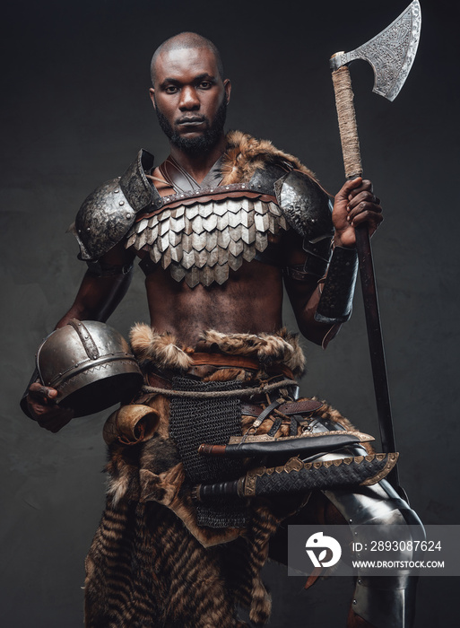 Brave african soldier from the past looking at camera holding an axe