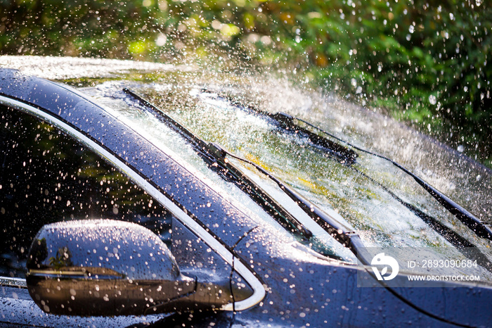 Car windshield with rain drops and frameless wiper blade