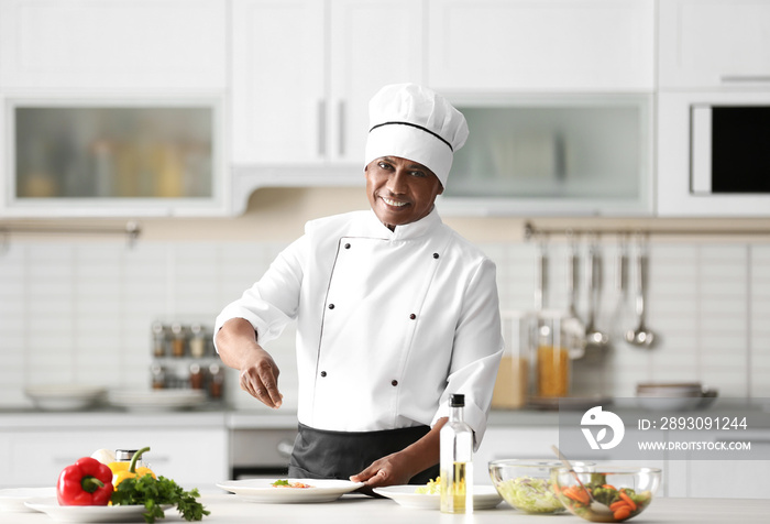 Mature Indian chef cooking in kitchen