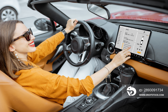 快乐的女人用数字仪表板控制汽车，在驾驶ca时切换自动驾驶模式