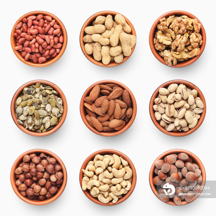 Set of various nuts in ceramic bowls isolated on white