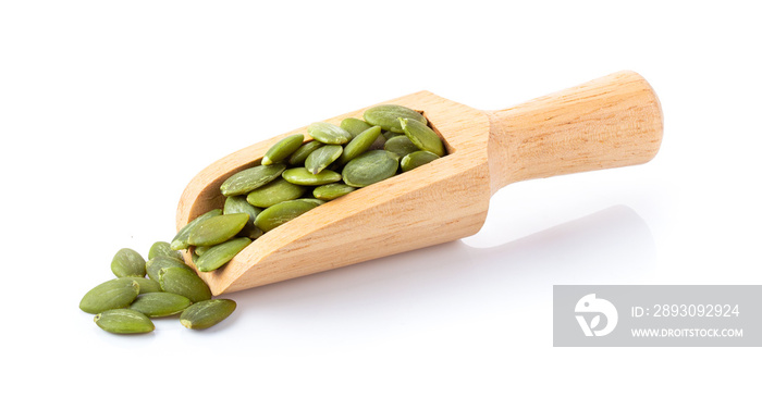 Pumpkin seeds in wood scoop  isolated on a white background. full depth of field