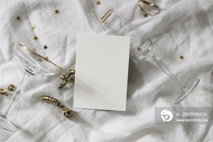 Happy New Year composition. Blank greeting card mockup scene. Champagne glasses with golden confetti