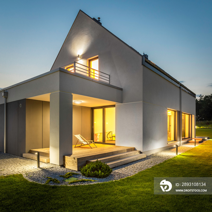 Exterior of illuminated house among green