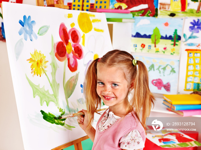 Child painting at easel.