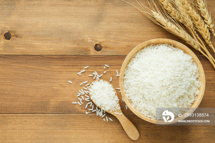 white rice (Thai Jasmine rice) in wooden bowl on wood background with copy space