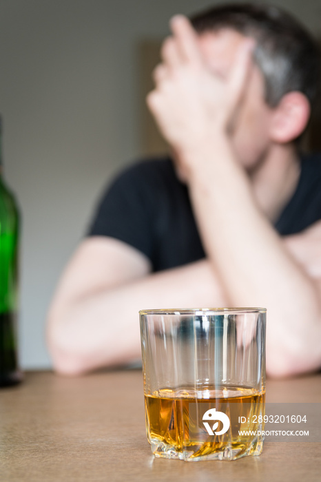 Homme alcoolique devant un verre