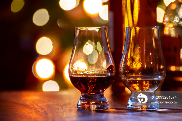 Glasses of scotch whisky served in bar in Edinburgh, Scotland, UK and pasry lights on background