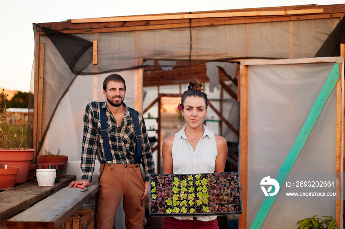 Portrait of young couple standing in front of shed