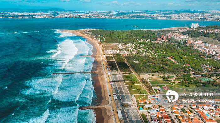 The Aerial footage of Costa da Caparica coastline of glorious sandy beaches, powerful Atlantic waves